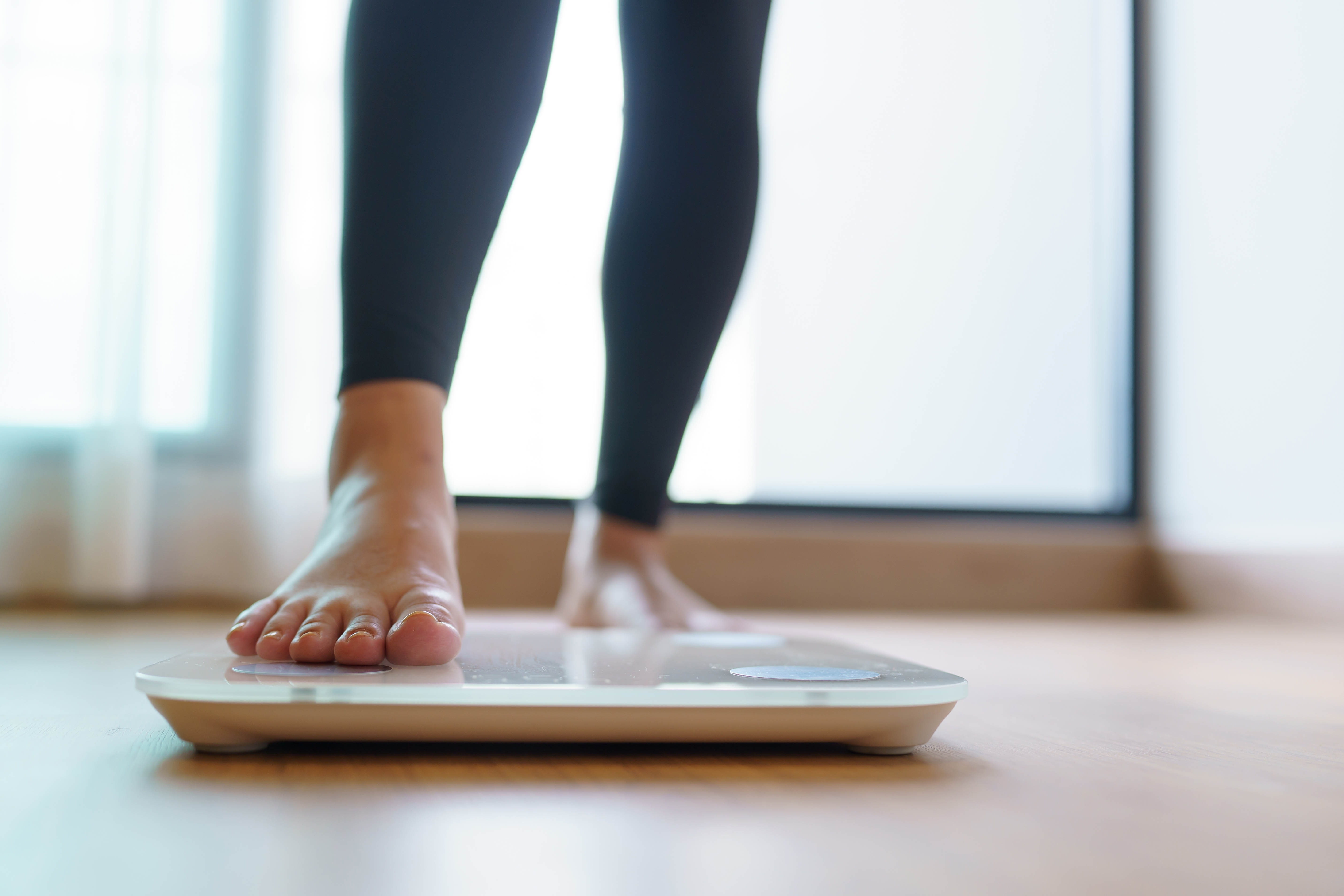 Close-up of a woman's foot stepping onto a scale Close-up of a woman's foot stepping onto a scale